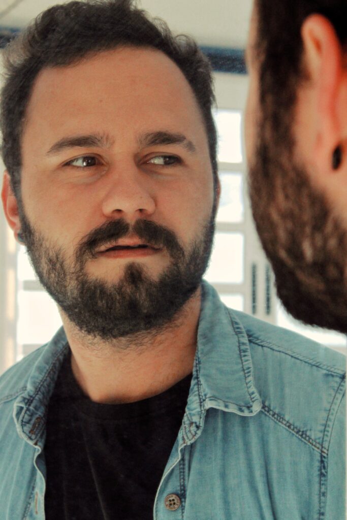Mężczyzna stylizujący brodę typu goatee pokazujący jaka broda pasuje do okrągłej twarzy