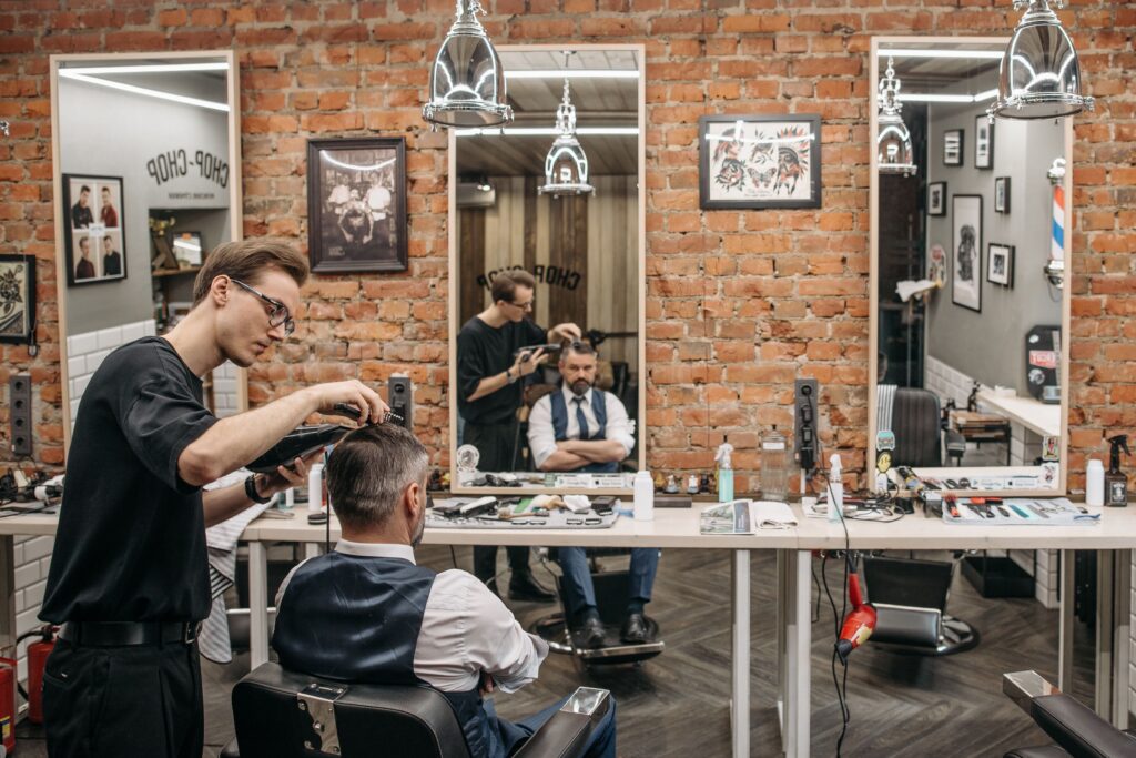 Barber strzygący włosy mężczyzny w profesjonalnym salonie barberskim
