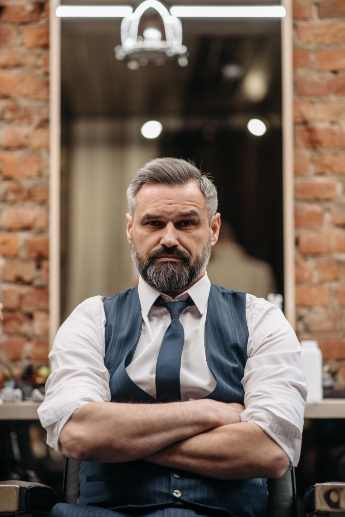 Mężczyzna z klasyczną fryzurą męską z przedziałkiem w eleganckim garniturze