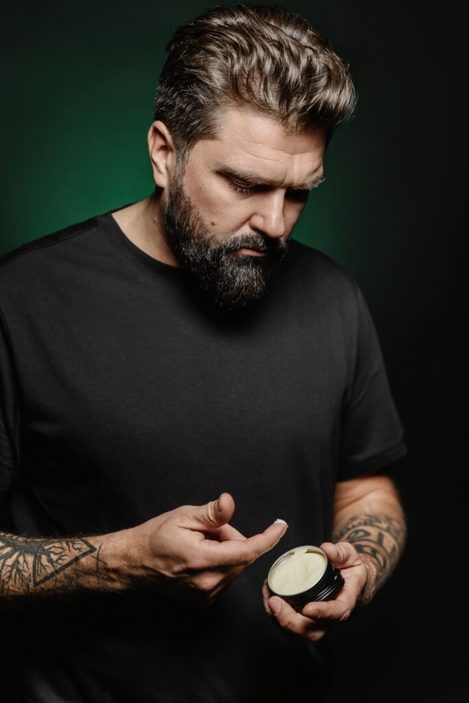 Mężczyzna nakładający pomadę do włosów w salonie barberskim