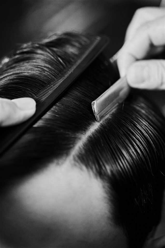 Mężczyzna stylizujący włosy męskie w salonie barberskim